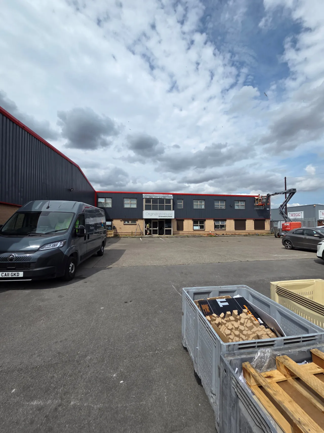 Company-supplied photograph of the Hull industrial unit with RAL 7024 cladding, traffic red trims and an access platform