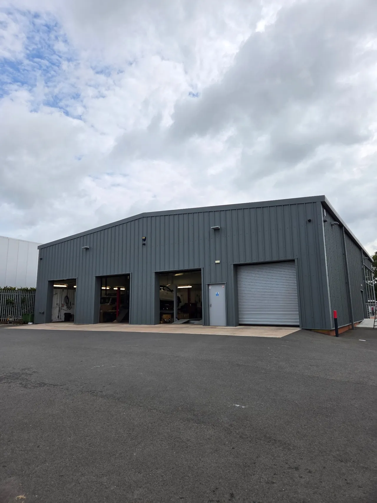 Company-supplied photograph: Completed mouse grey cladding around the showroom workshop bays