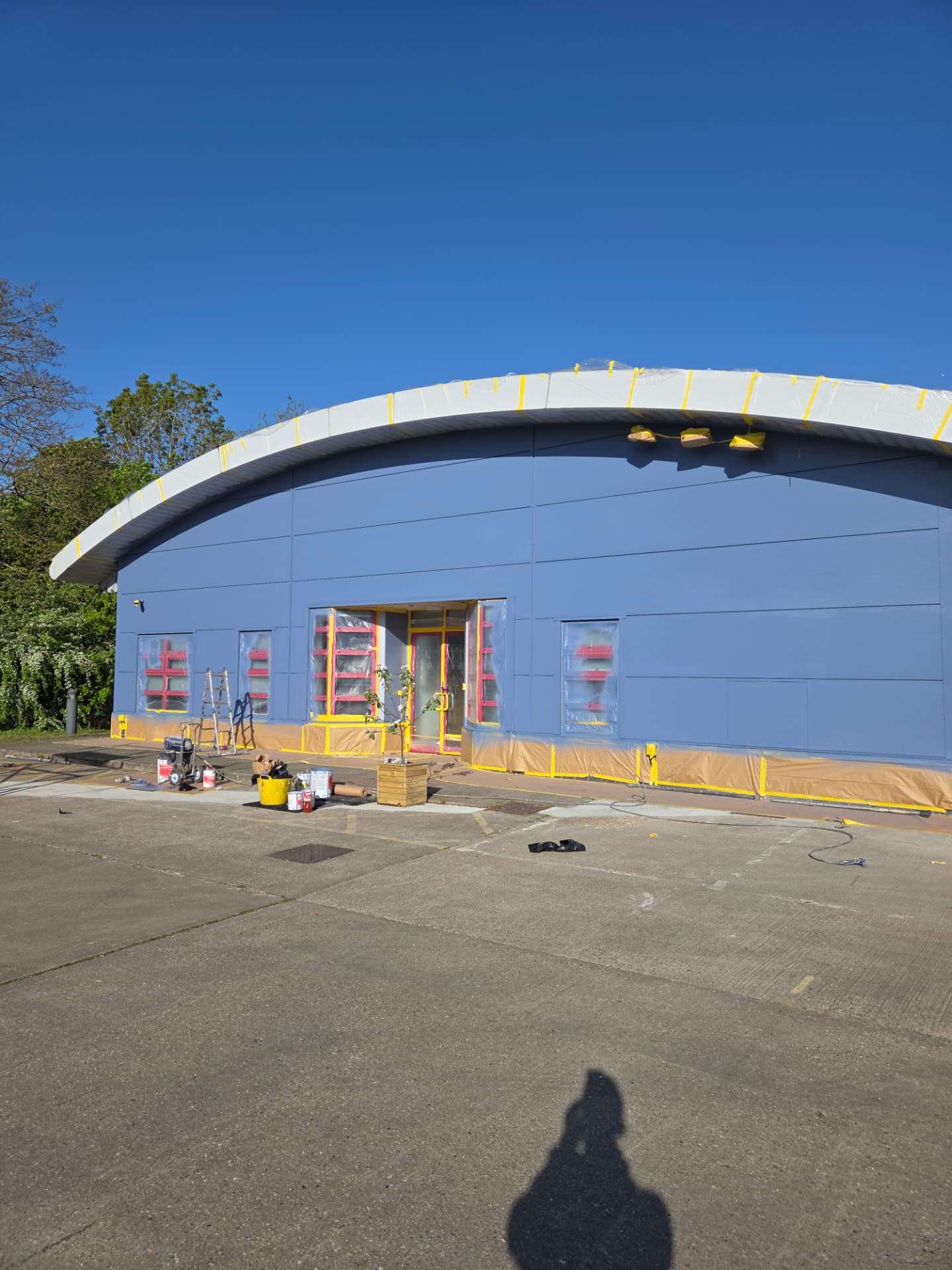 Company-supplied photograph of the fire station cladding resprayed in ocean blue with the glazing still masked