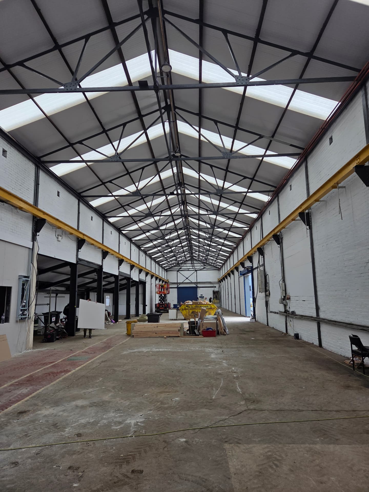 Company-supplied photographs of a Wakefield warehouse interior with white walls and recoated black steelwork