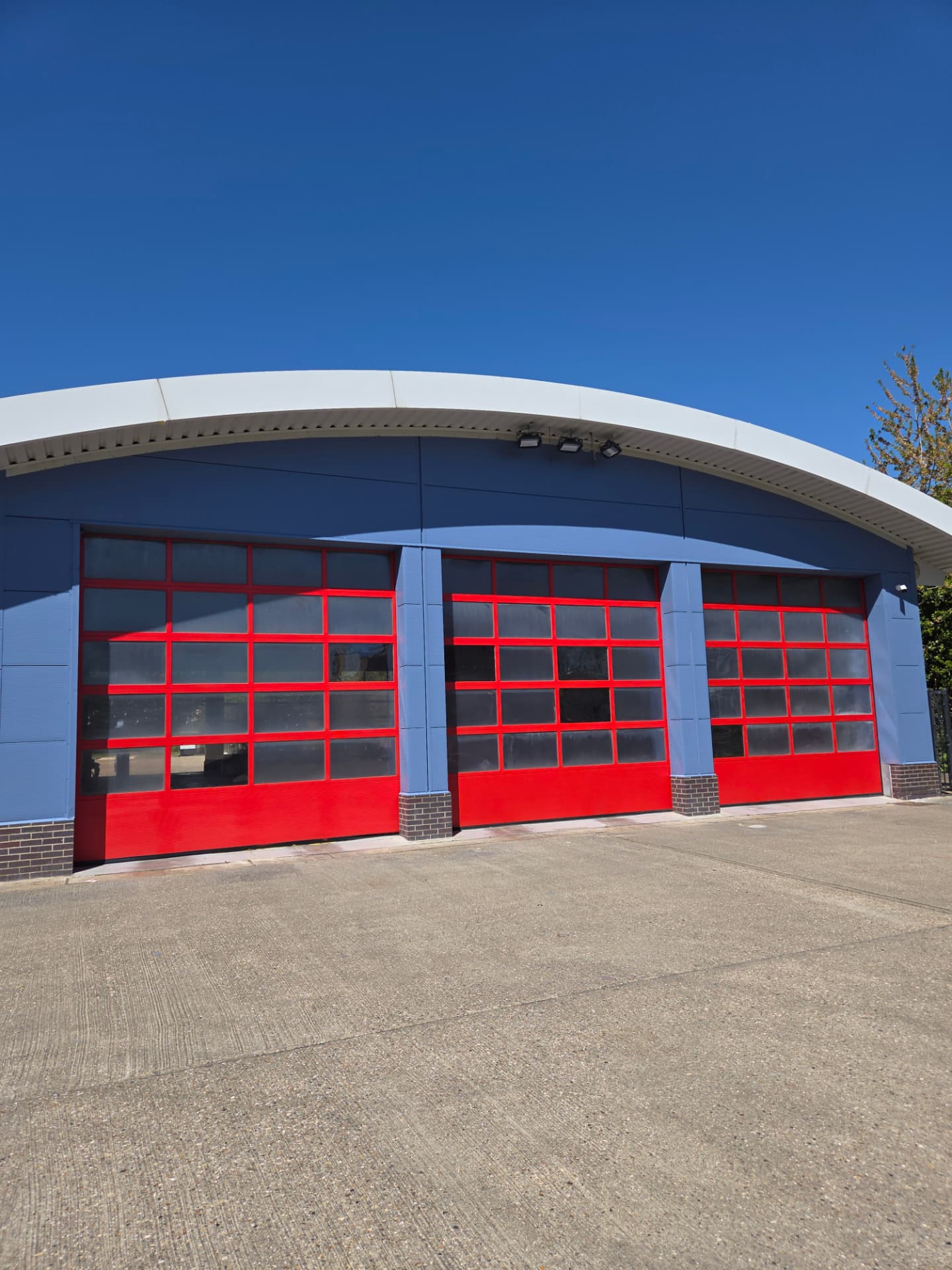 Company-supplied photograph: Company-supplied photograph of the completed St Albans Fire Station frontage with ocean blue cladding and traffic red appliance-bay doors