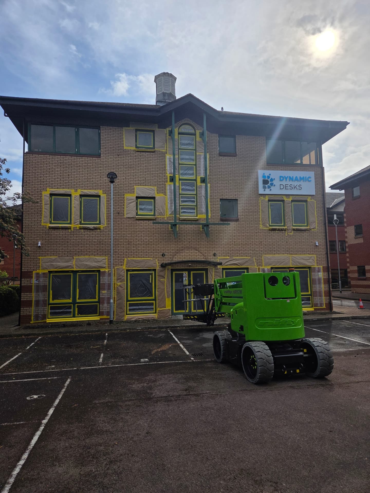 Company-supplied photograph: Dynamic Desks office frontage before completion with glazing and adjoining brickwork masked for respraying