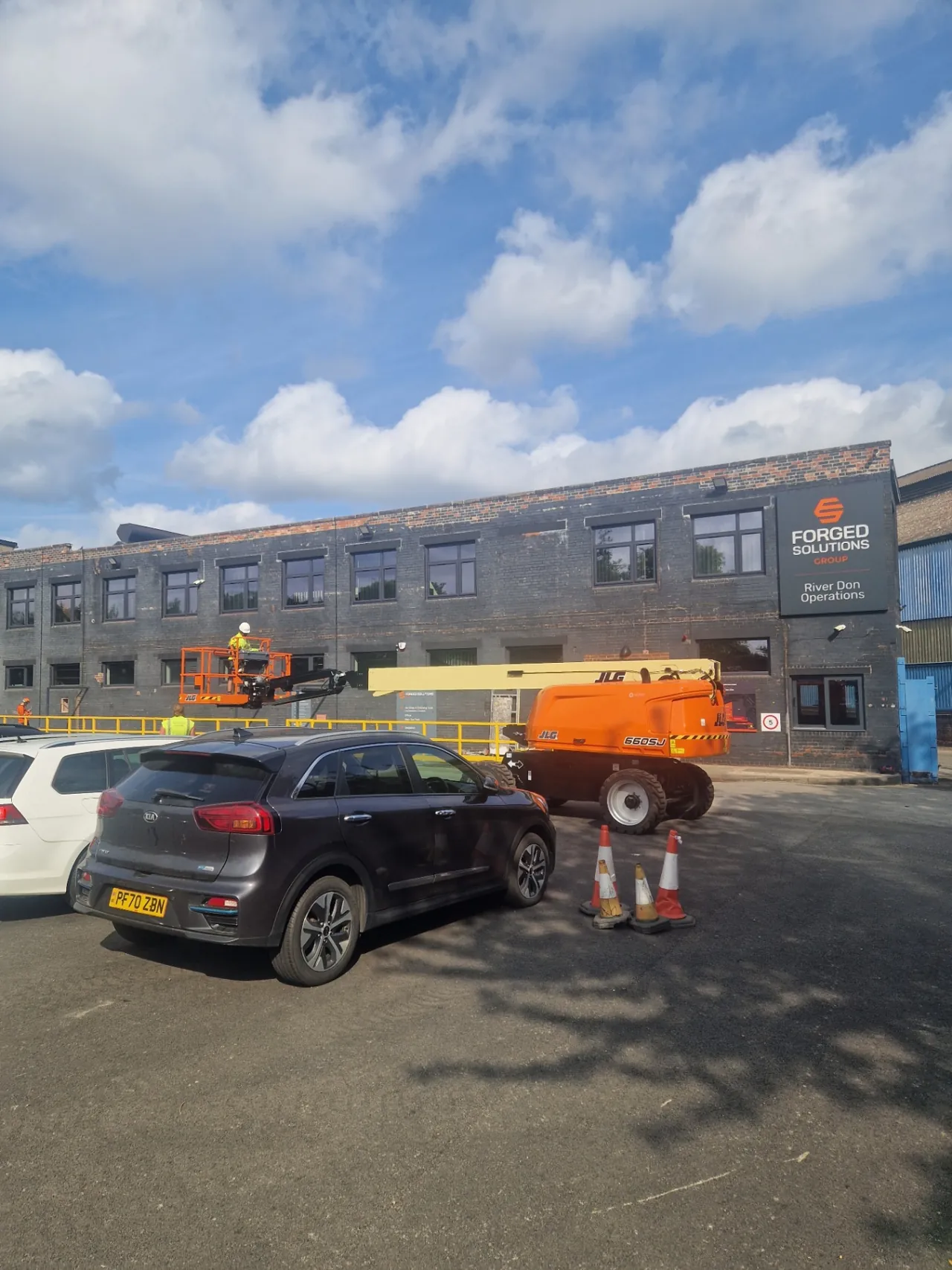 Company-supplied photograph: Original office-block frontage with boom lift on site