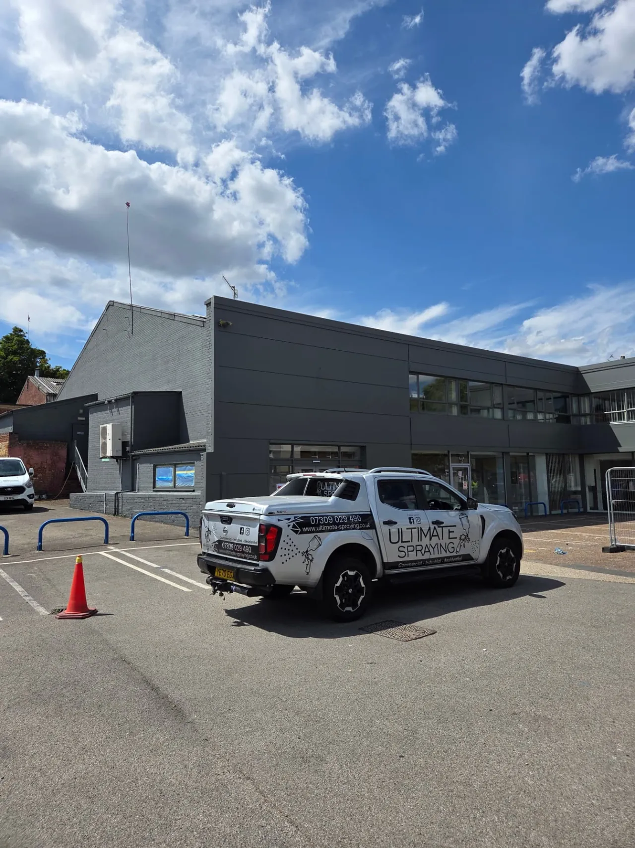 Company-supplied photograph of the Ford showroom in Peterborough with RAL 7005 mouse grey cladding, windows and doors and the Ultimate Spraying vehicle