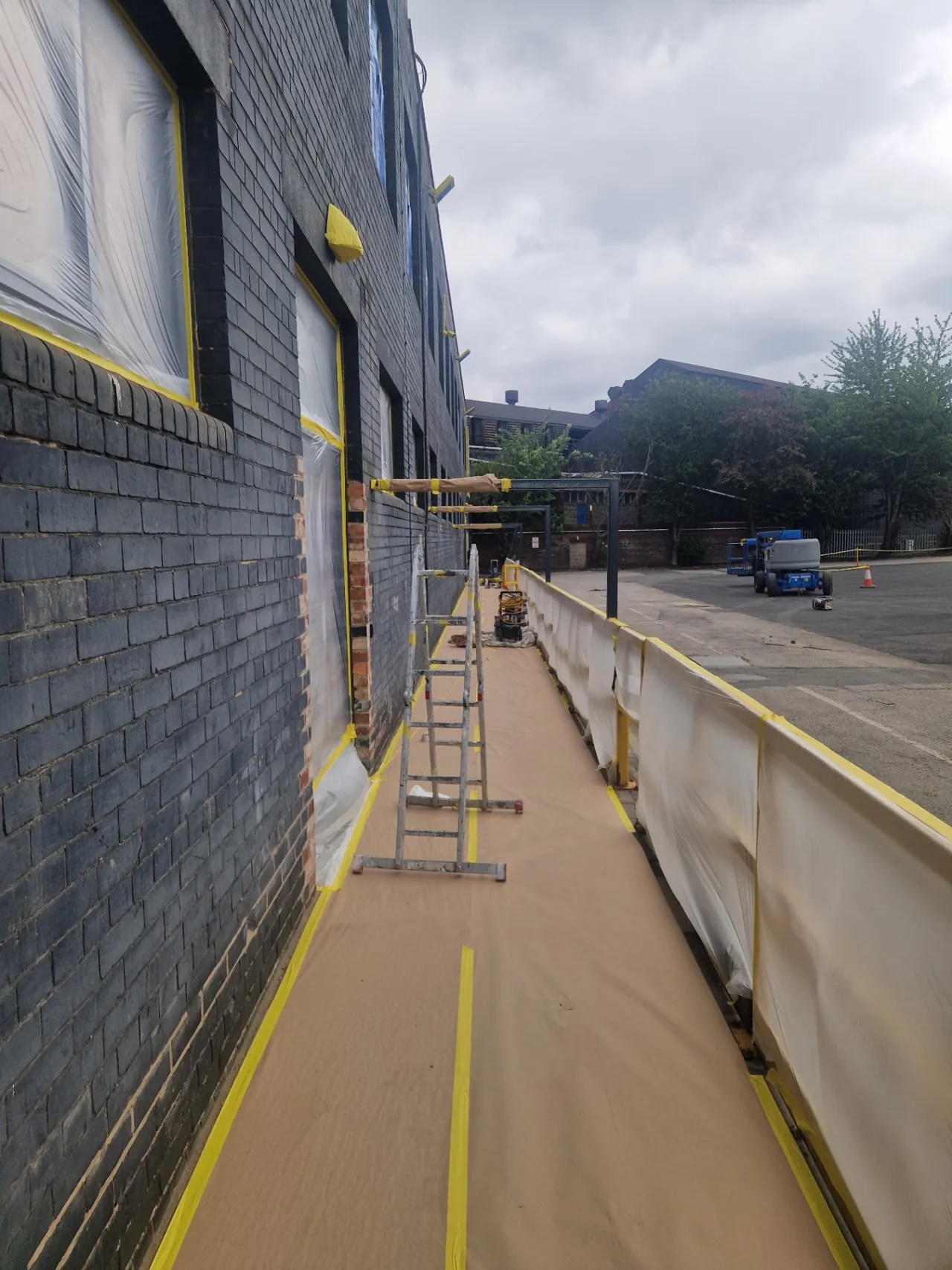 Company-supplied photograph: Masked glazing, protected walkway and barriers beside the office block