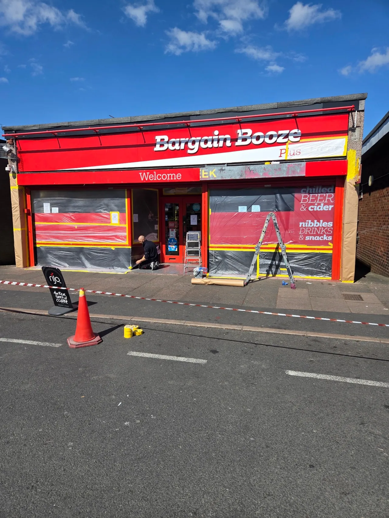 Company-supplied photograph: Company-supplied photograph of the Bargain Booze shopfront masked and protected during preparation
