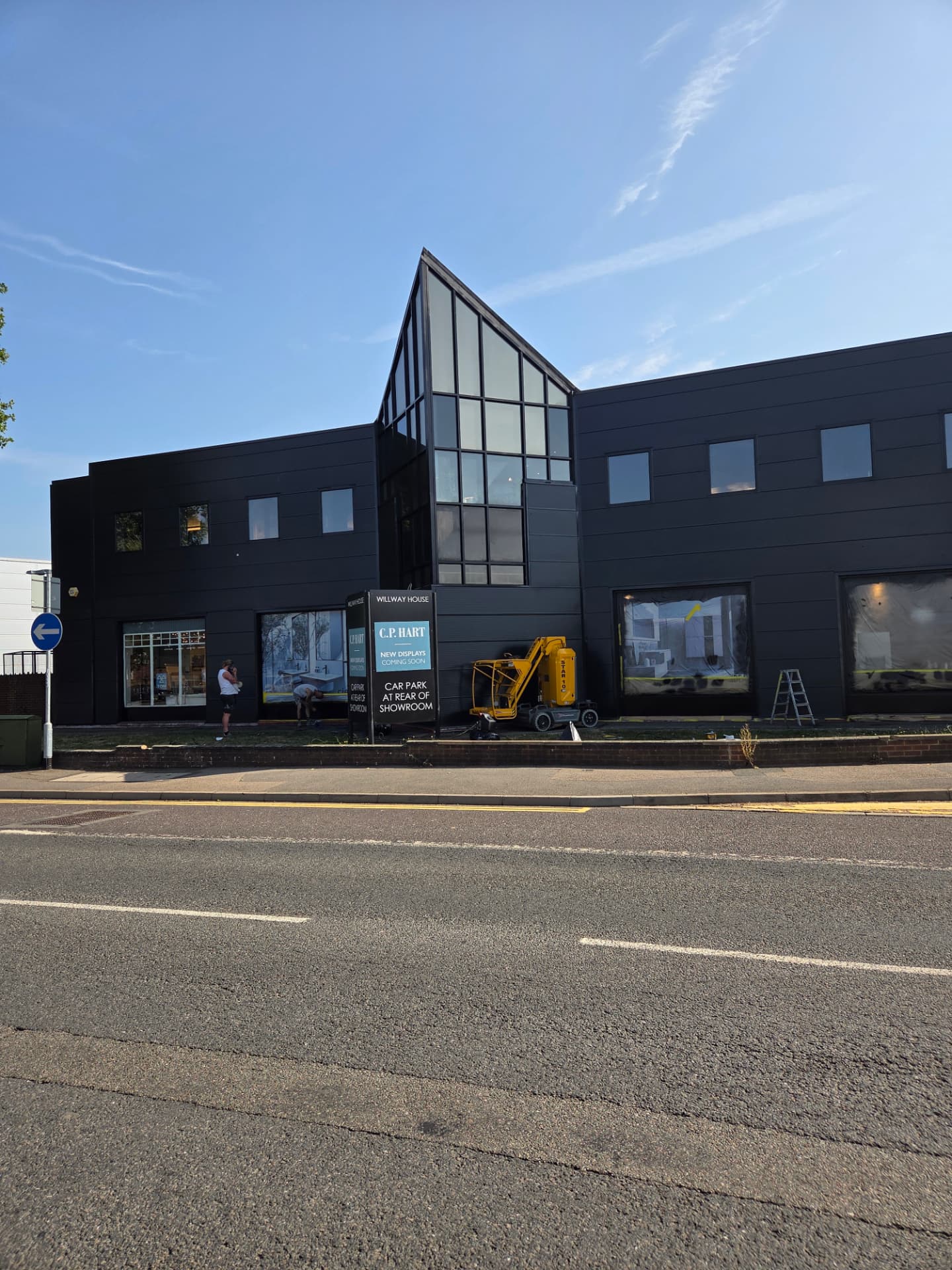 Company-supplied photograph of the completed showroom frontage with black cladding and an access machine on site