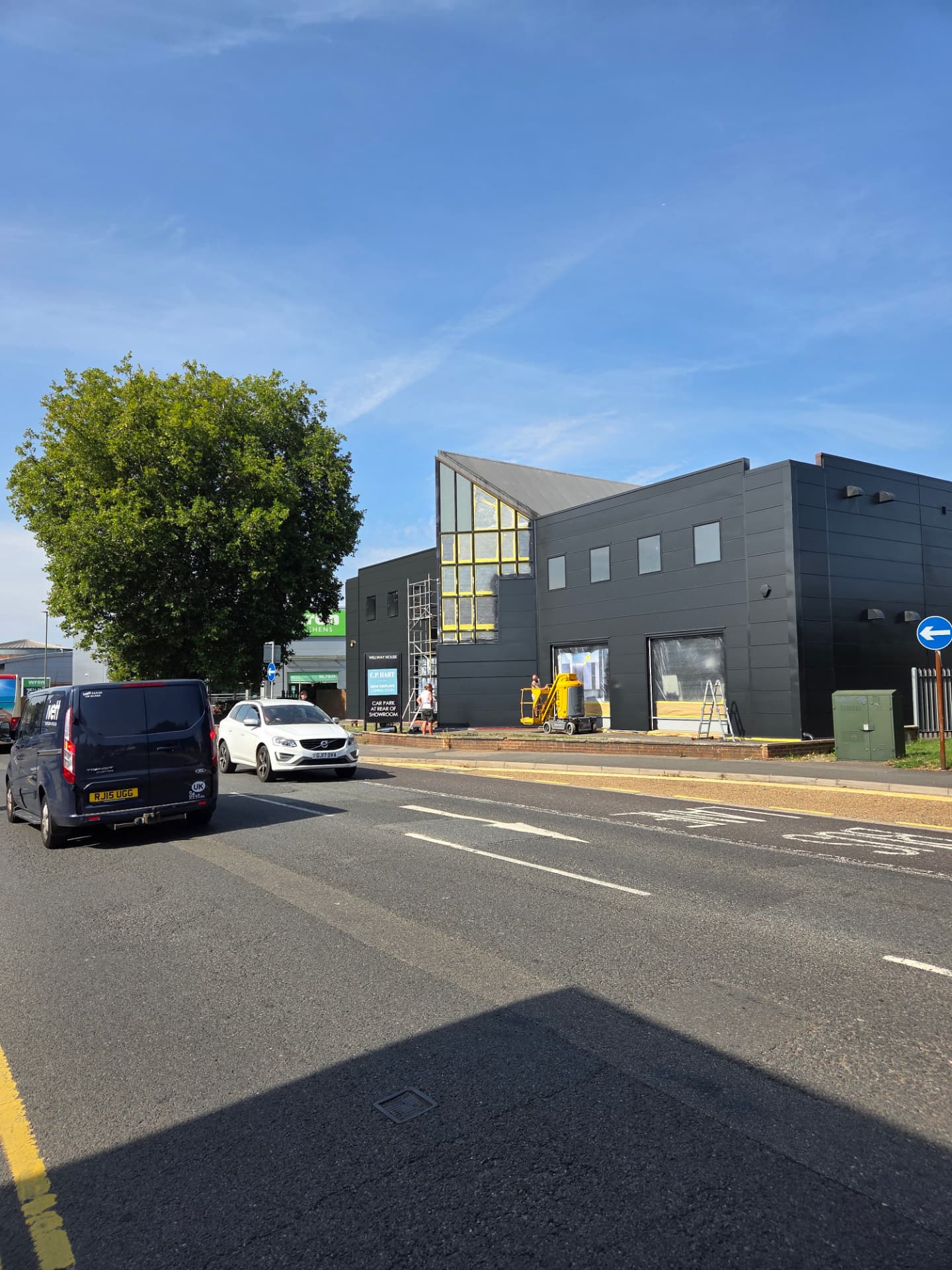 Company-supplied photograph of the showroom street elevation with resprayed black cladding and access equipment in place