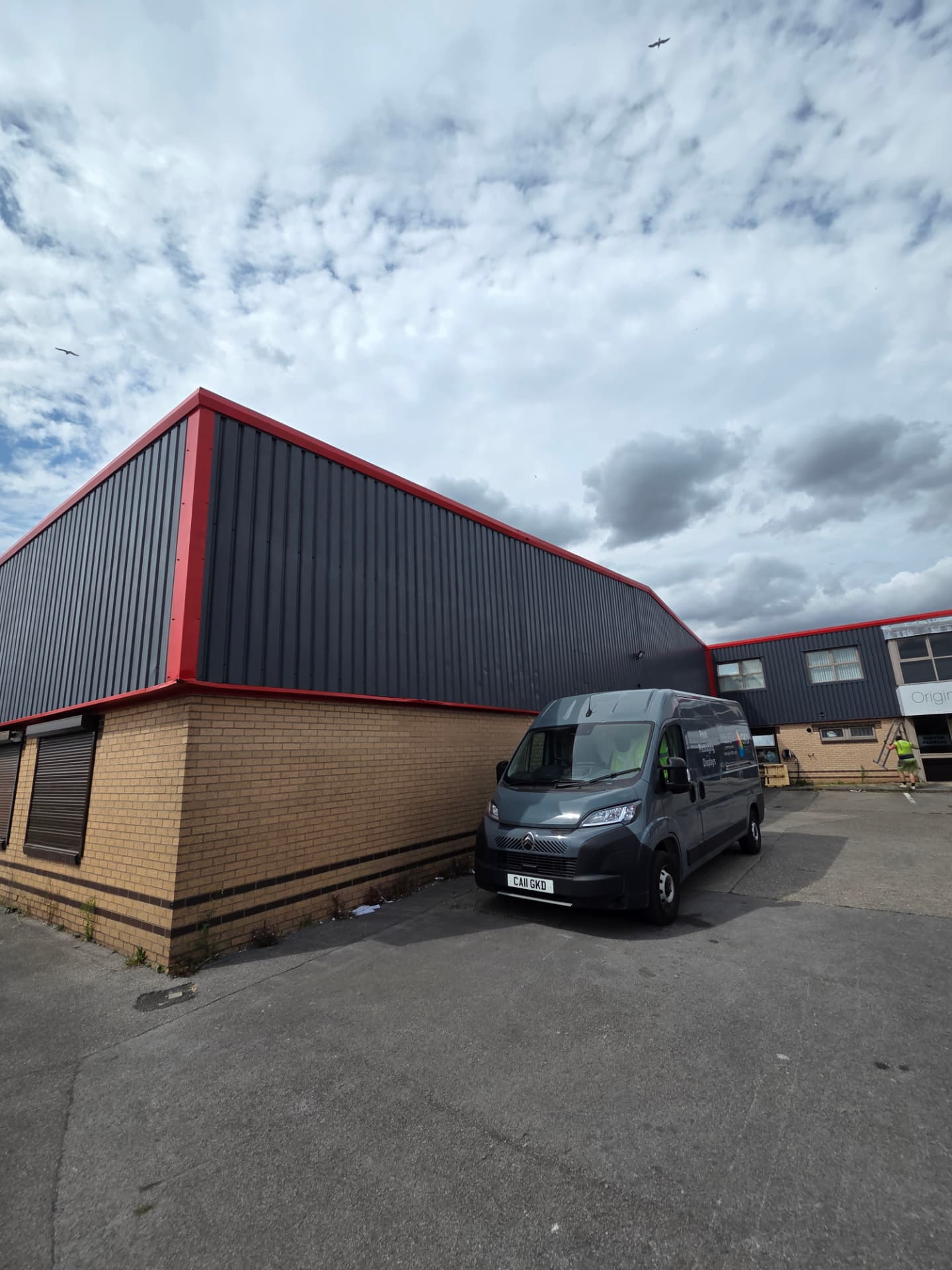 Company-supplied photograph of completed RAL 7024 cladding and traffic red trims at the Hull building corner