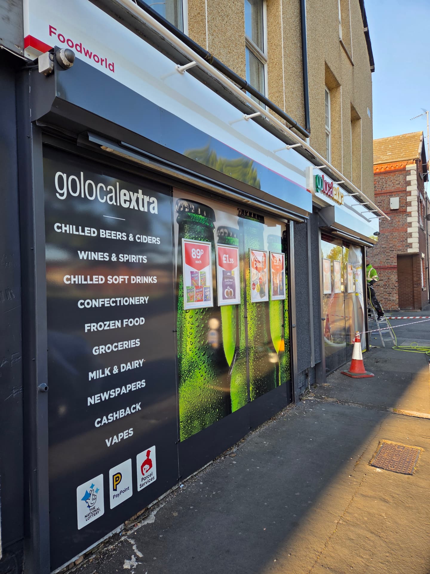 Company-supplied photograph of a Go Local shopfront being sprayed on site with protection around the door