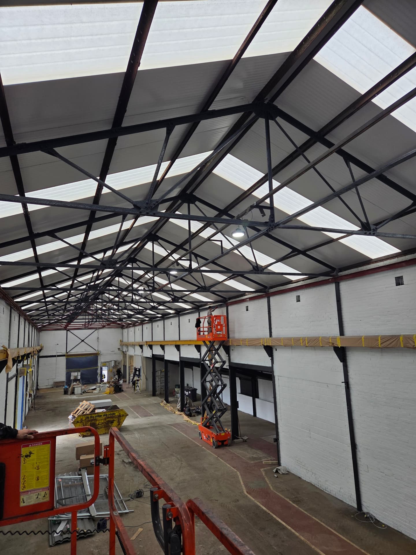 Company-supplied photograph of a large warehouse interior with recoated black steelwork, white walls and roof skylights