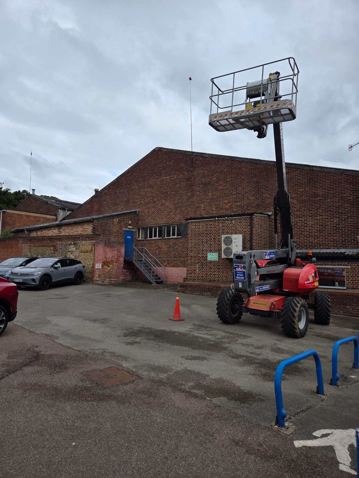 Company-supplied photograph of a boom lift positioned in the Ford showroom yard