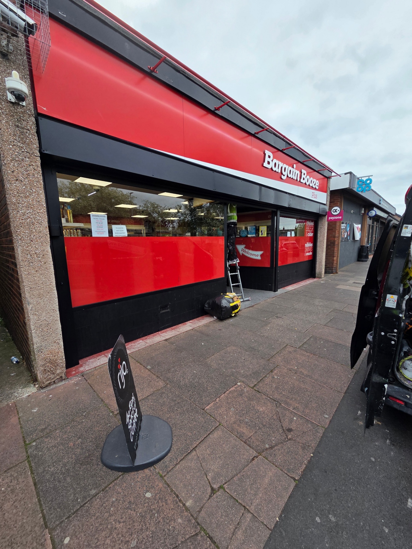 Company-supplied photograph of the completed Bargain Booze shopfront with red fascia, black framing and red window banding
