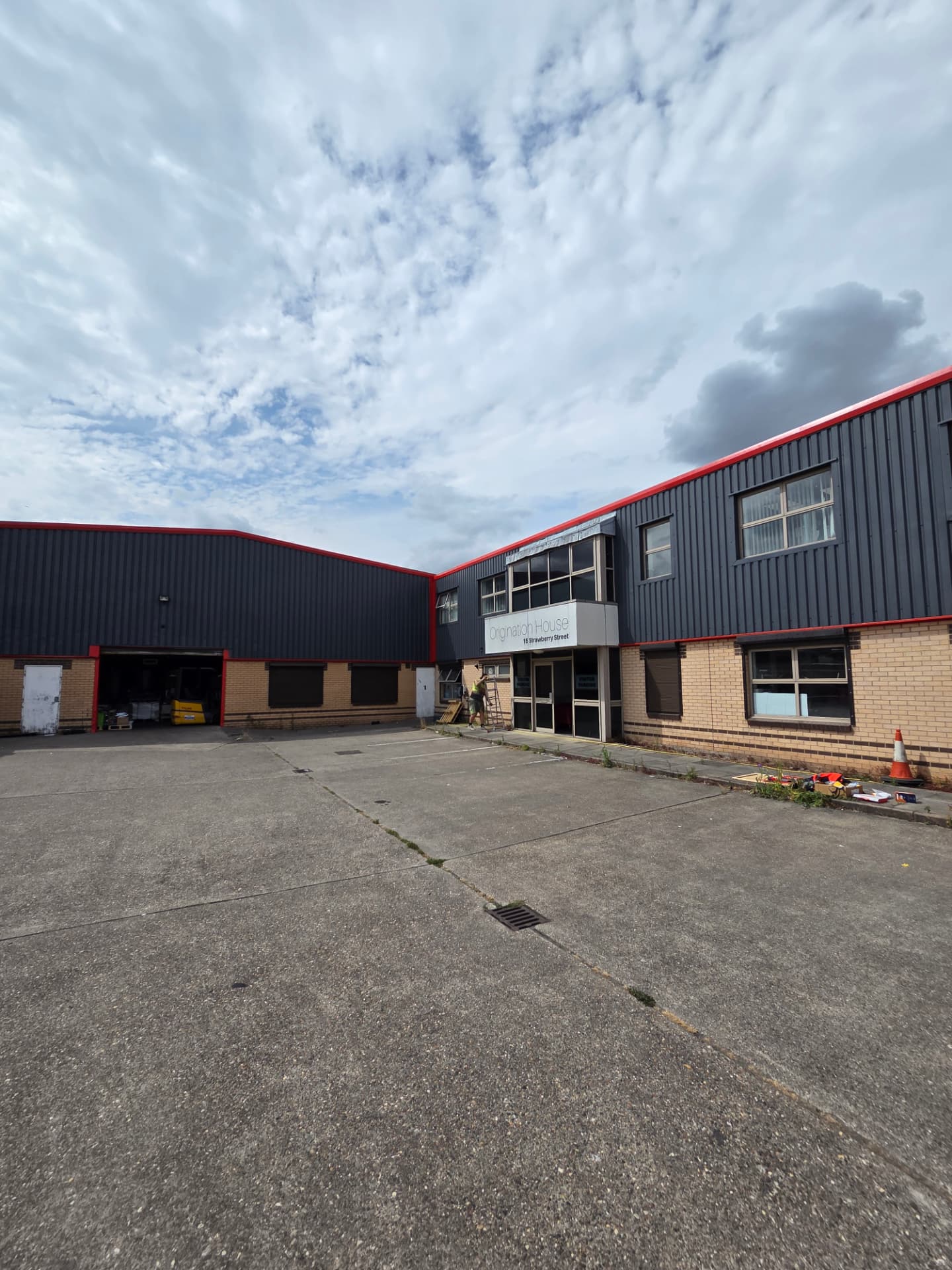 Company-supplied photograph of the Hull entrance elevation with RAL 7024 cladding and traffic red trims