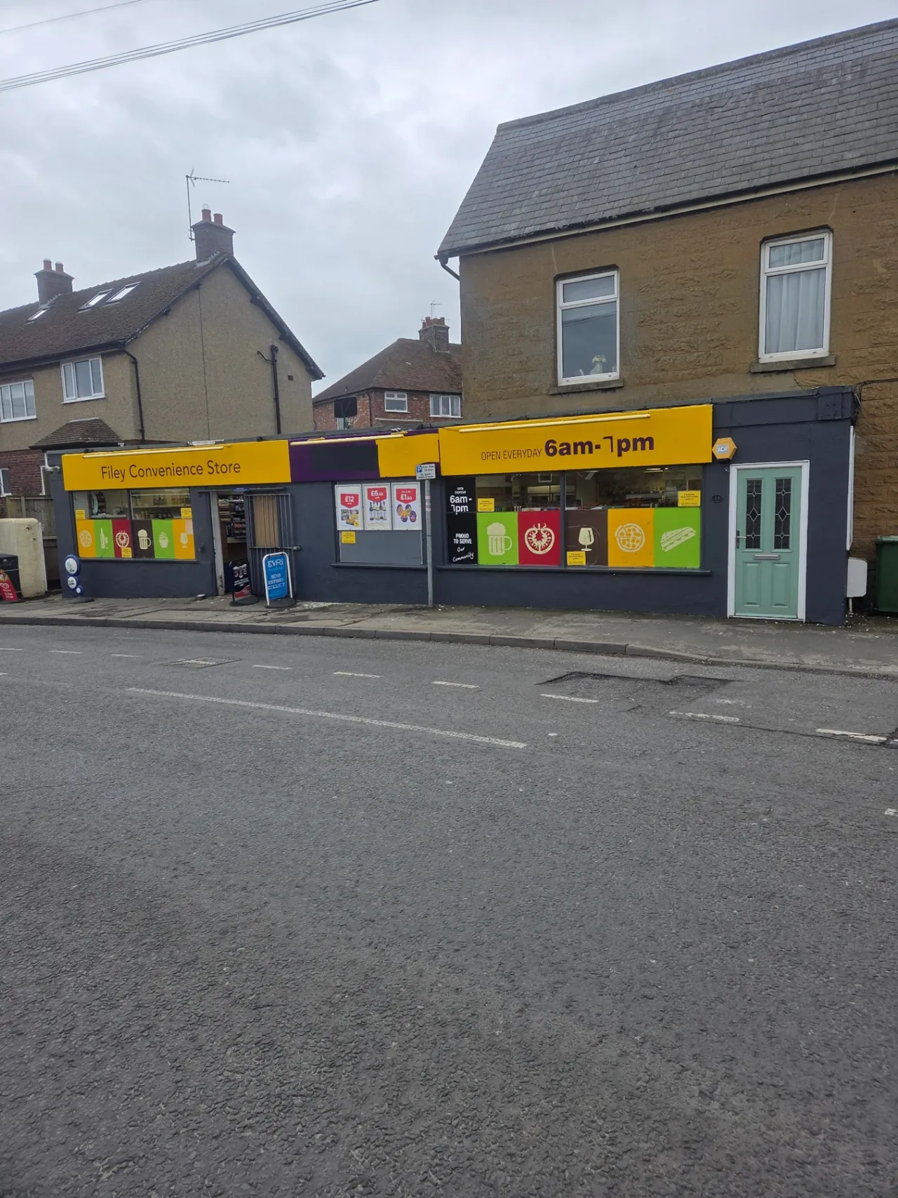 Company-supplied photograph of Filey Convenience Store after the shopfront was resprayed in a dark grey finish with the yellow fascia retained
