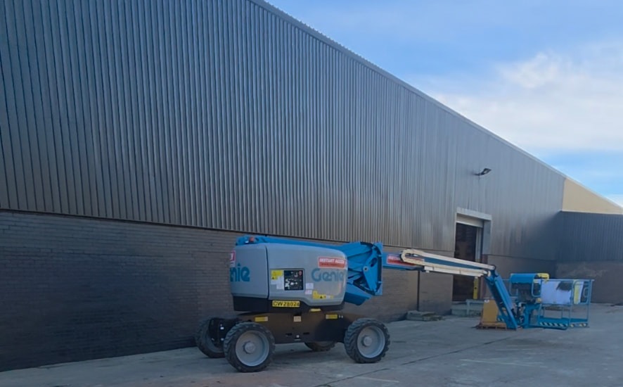 Company-supplied photograph of a boom lift beside a charcoal-clad commercial building