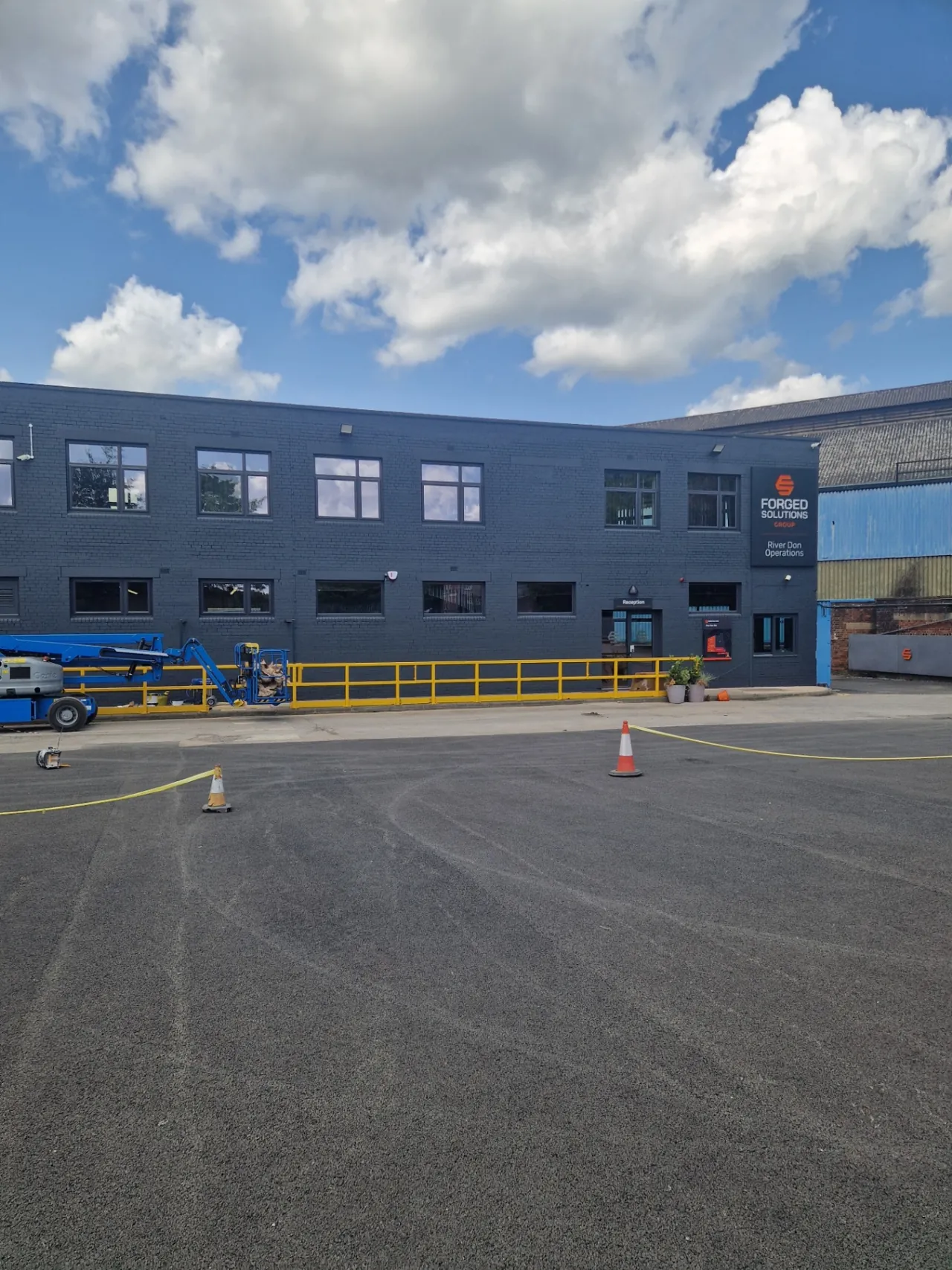 Company-supplied photograph: Resprayed office-block frontage with access equipment on site