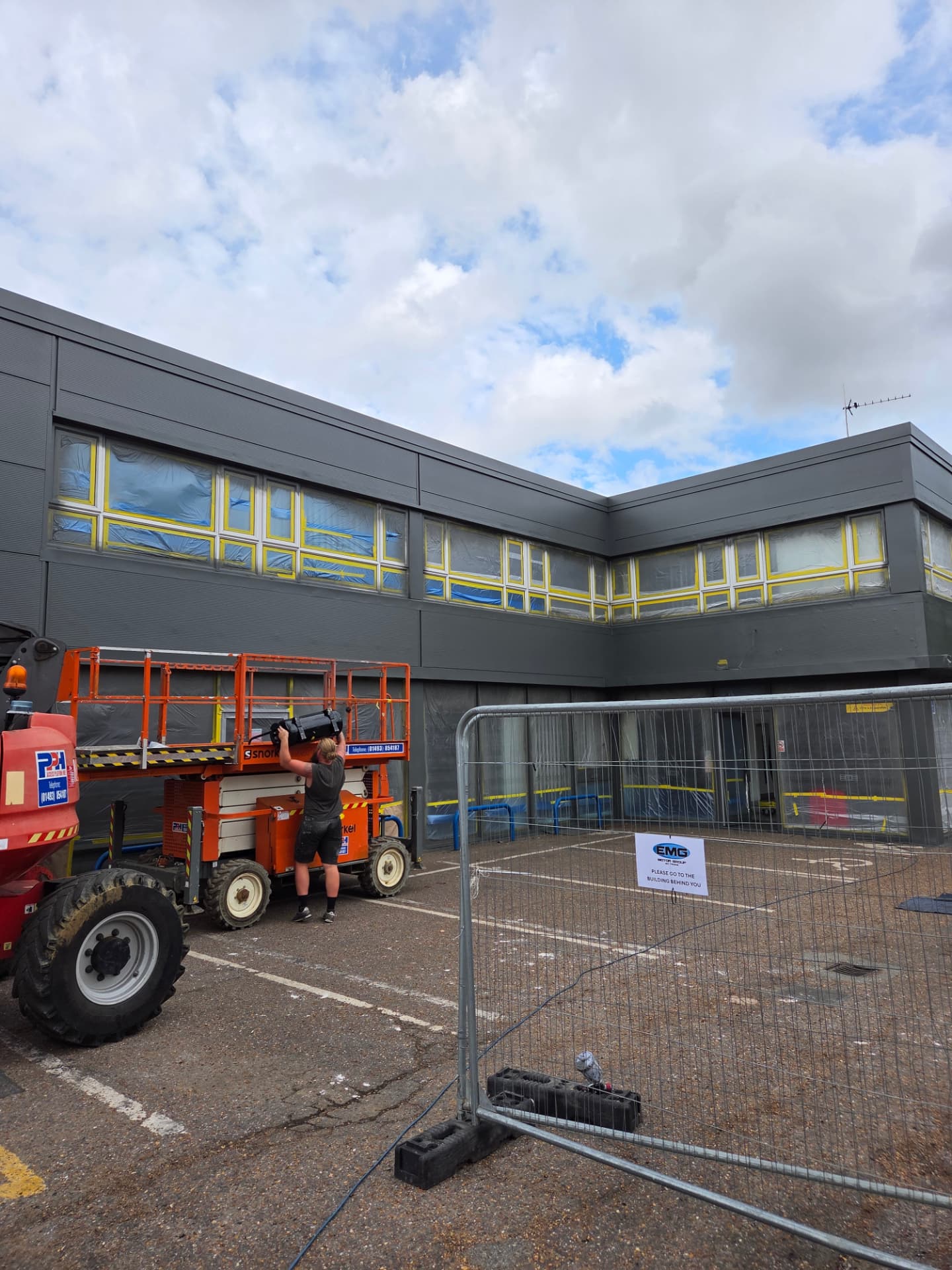 Company-supplied photograph of the Ford showroom during respraying with masked glazing, boom lift and scissor lift