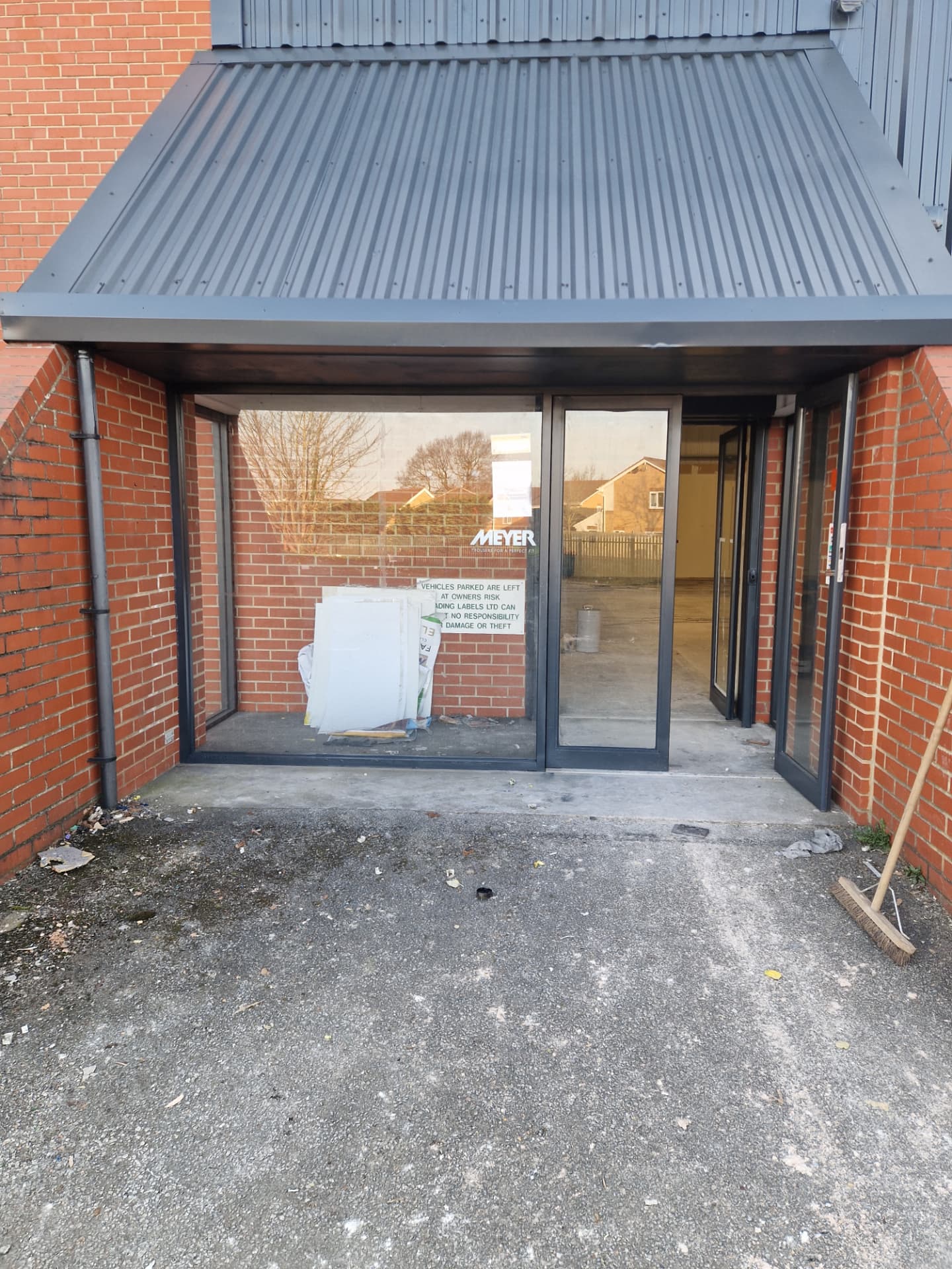 Company-supplied photograph of the completed X Martial Arts entrance canopy and doors in RAL 7016 anthracite grey