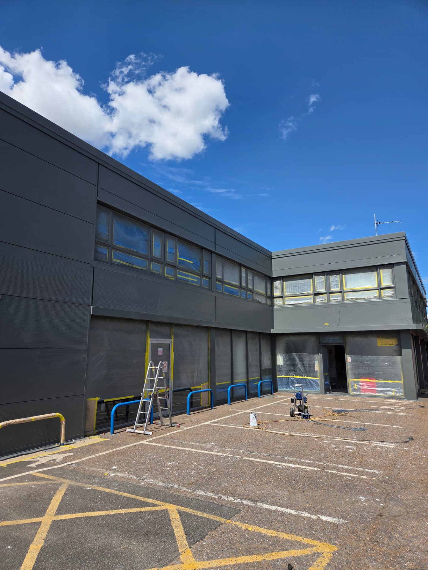 Company-supplied photograph of resprayed Ford showroom cladding with masking remaining on windows and doors