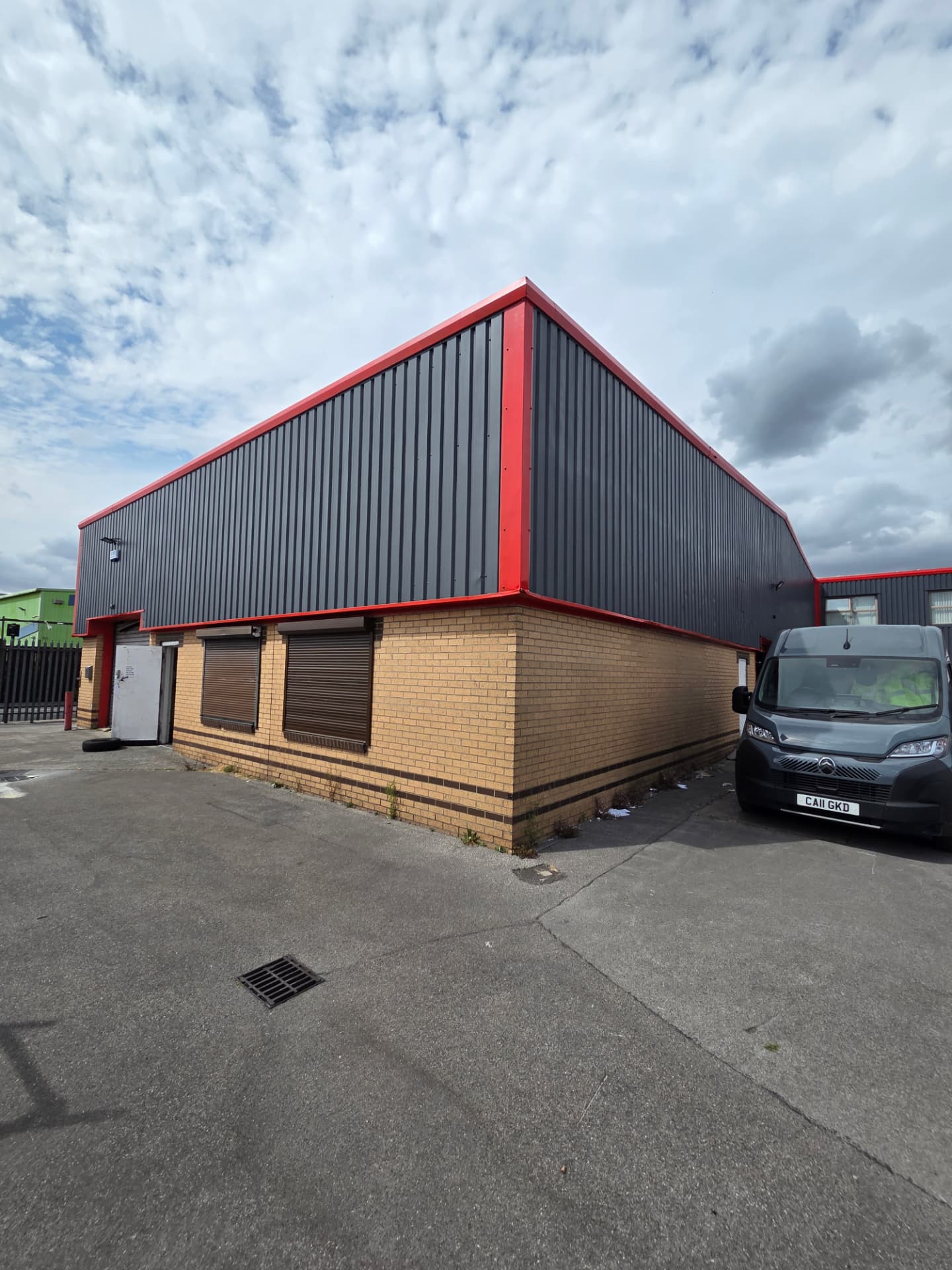 Company-supplied photograph of the completed Hull gable with RAL 7024 cladding and RAL 3020 traffic red trims