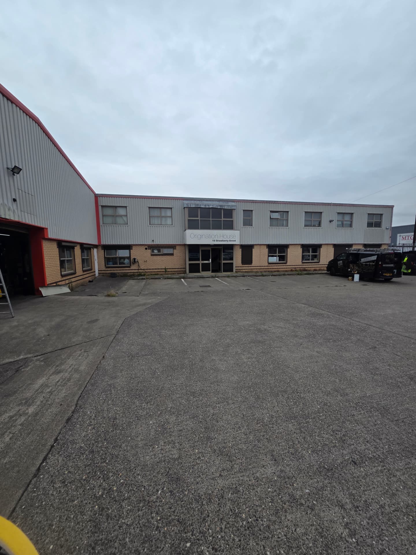 Company-supplied photograph: Hull industrial unit frontage with original light grey cladding before respraying