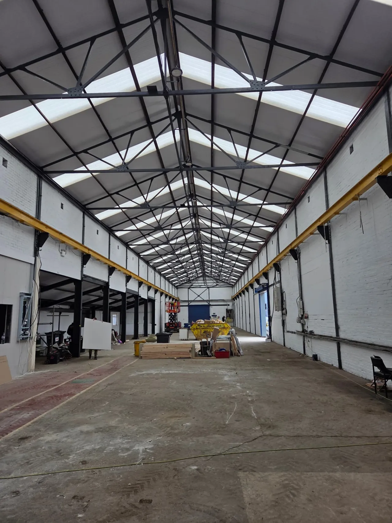 Company-supplied photographs of a Wakefield warehouse interior with white walls and recoated black steelwork
