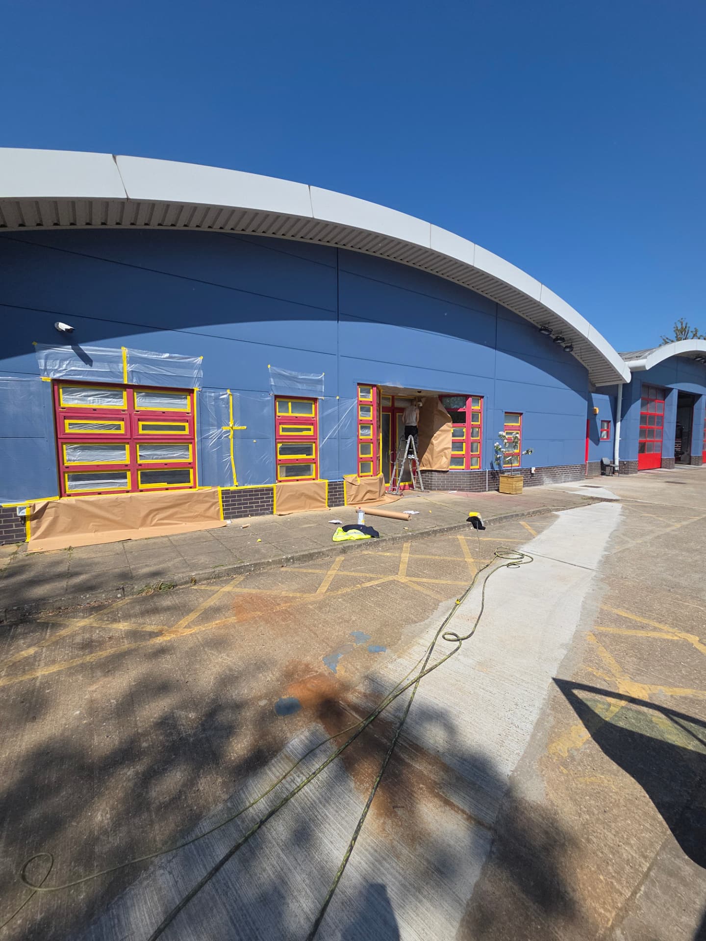 Company-supplied photograph of the entrance elevation during the works with masked windows and an access ladder